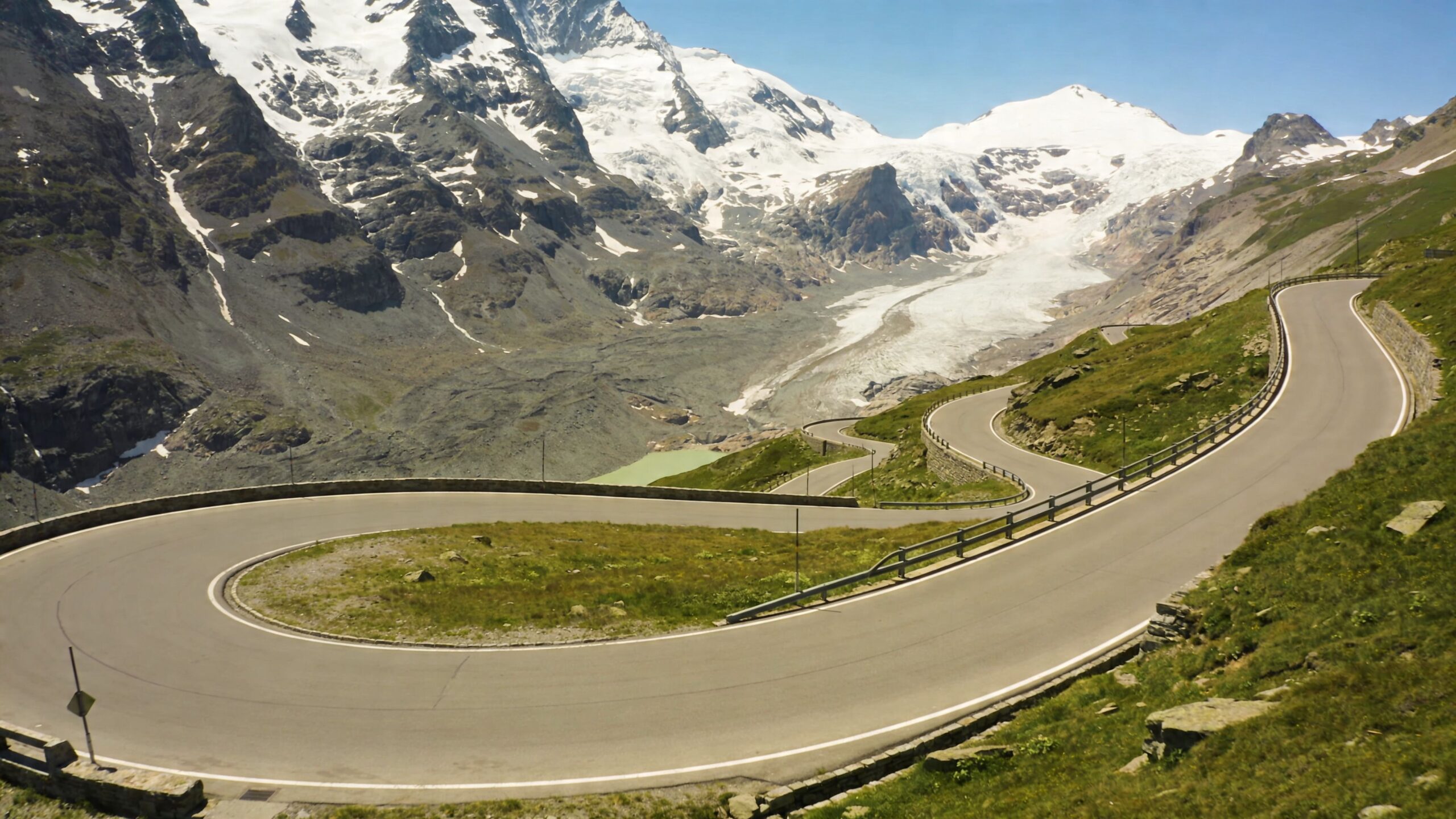 A scenic winding mountain road leading through the majestic Grossglockner High Alpine Road in the Austrian Alps.