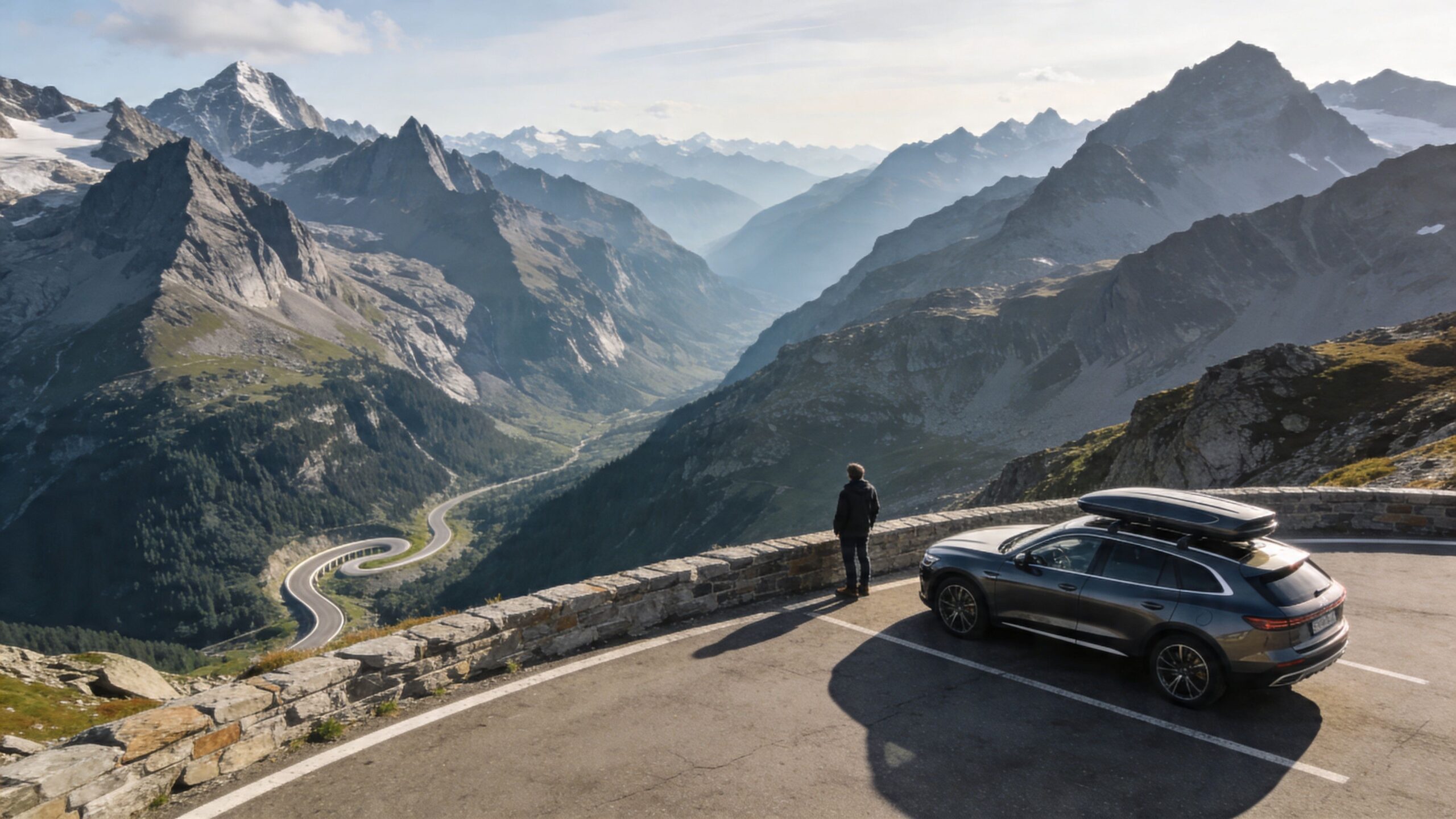 A person standing by a luxury car parked on the Grossglockner High Alpine Road overlooking scenic mountain views.