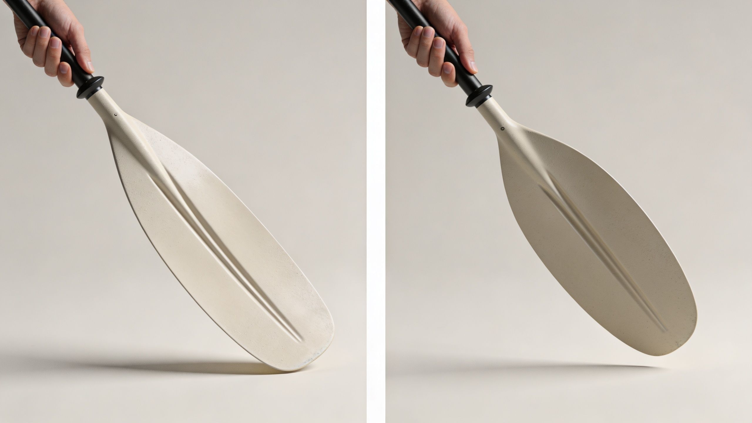 A pair of light-colored kayak paddles held by hand against a clean, plain beige studio background.