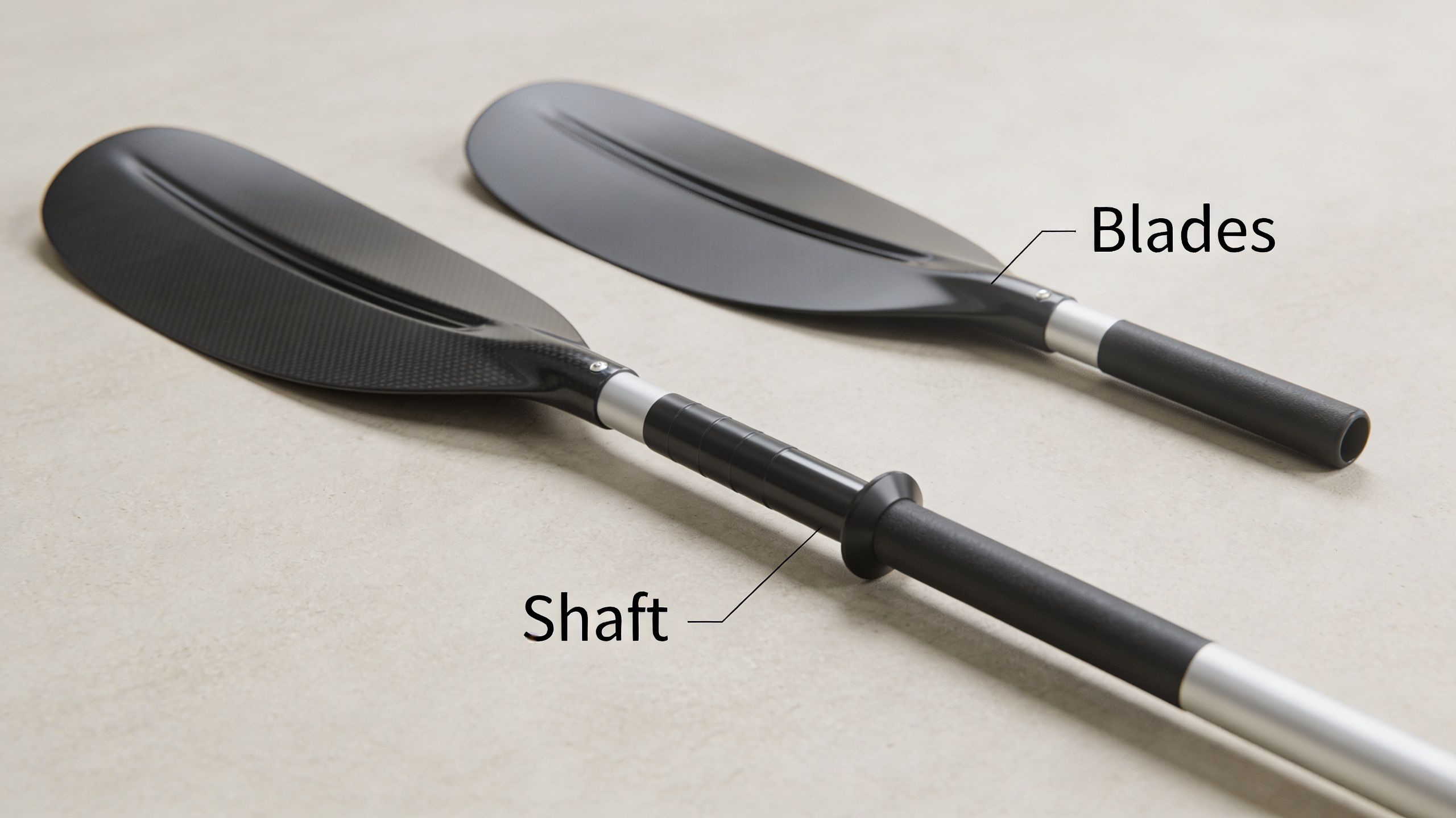 Two black kayak paddle blades and shafts lying on a neutral light-colored background.