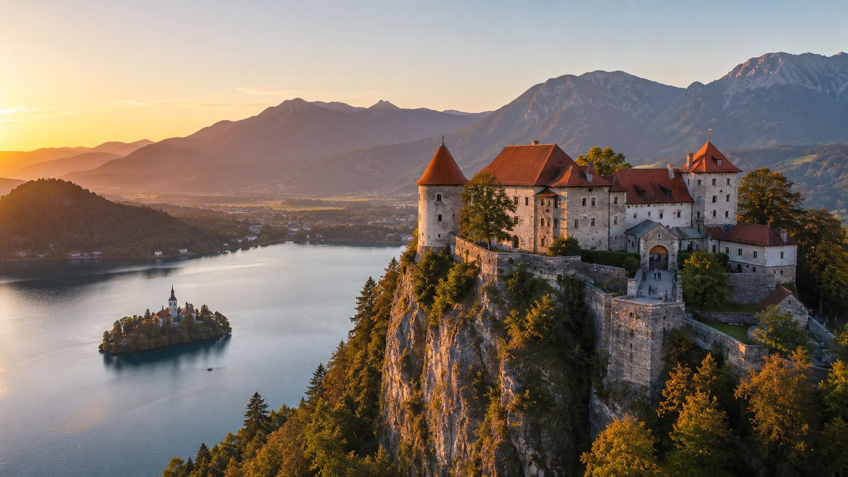 A breathtaking sunrise view of Bled Castle perched on a cliff overlooking Lake Bled and its island.