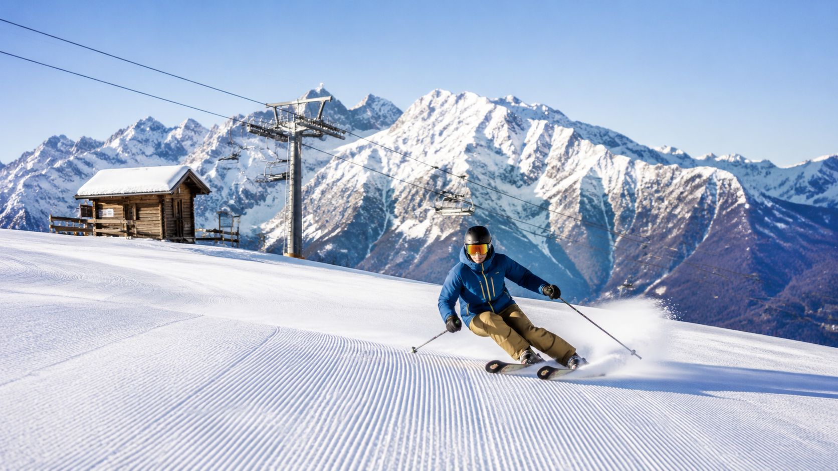 A skier carving through fresh groomed snow on a sunny day in the Slovenian mountains